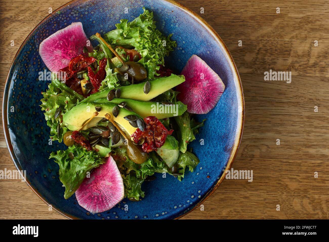 Diät-Menü. Gesunder Salat aus frischem Gemüse - Avocado, Rucola, Rettich auf einer Schüssel. Vegane Küche. Flach liegend. Banner. Draufsicht Stockfoto