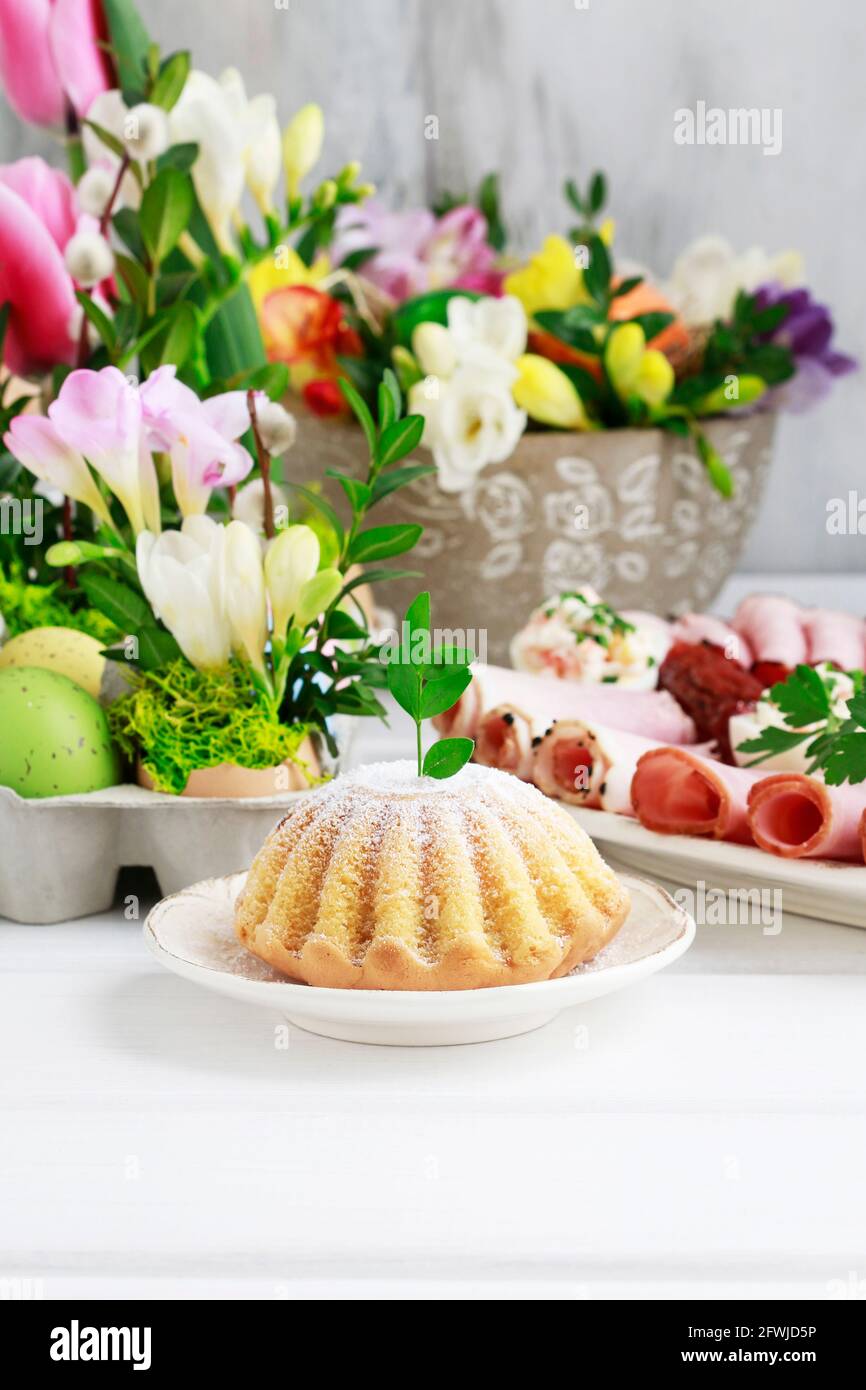 Festliche Ostertafel mit traditionellen Kuchen- und Blumendekorationen. Festliche Einrichtung Stockfoto
