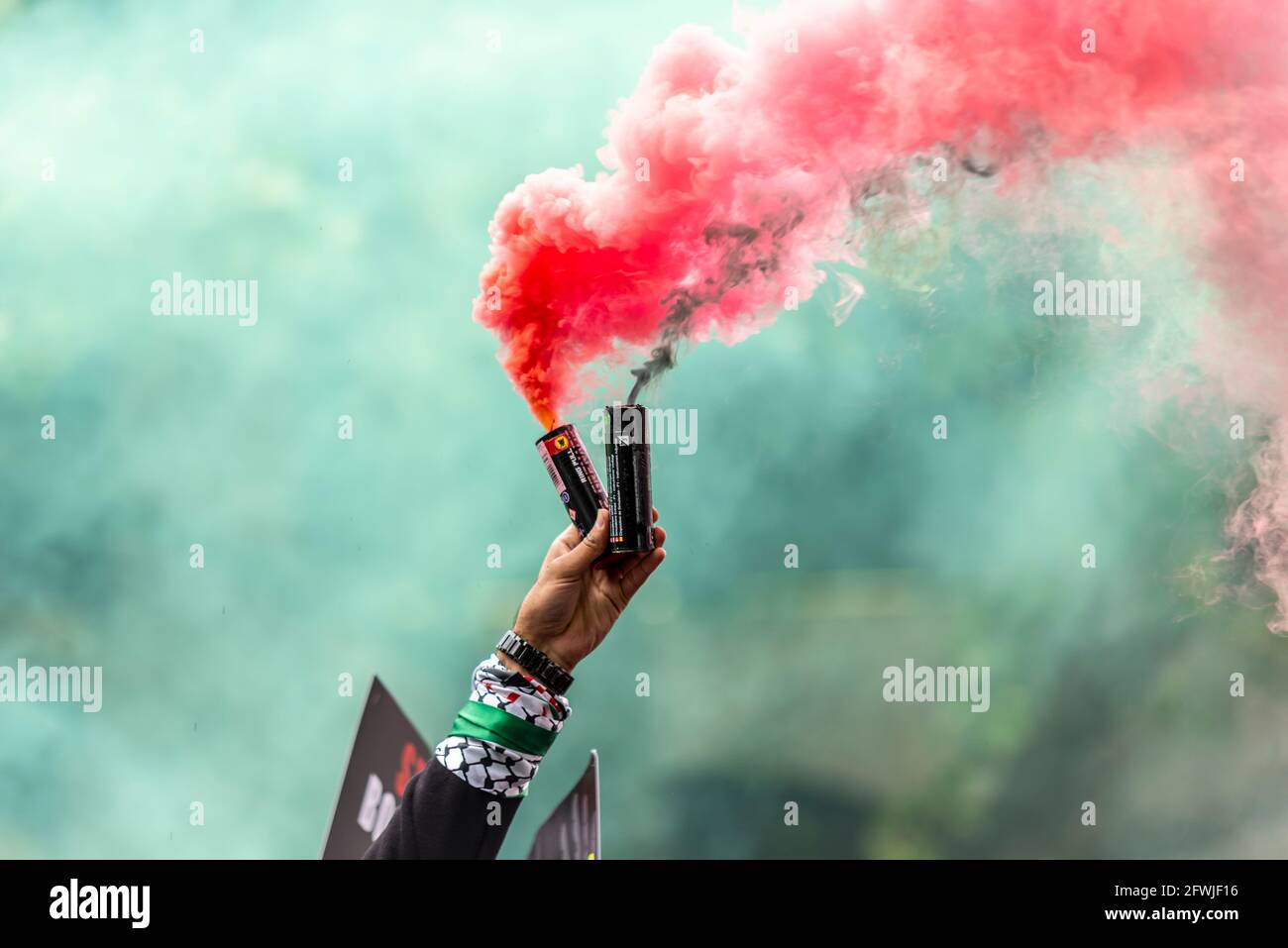 Hand eines Protesters bei der Nationalen Demonstration für Palästina, Freie Palästina, in London, Großbritannien, die rote und grüne Fackeln, ihre nationalen Farben ließ Stockfoto