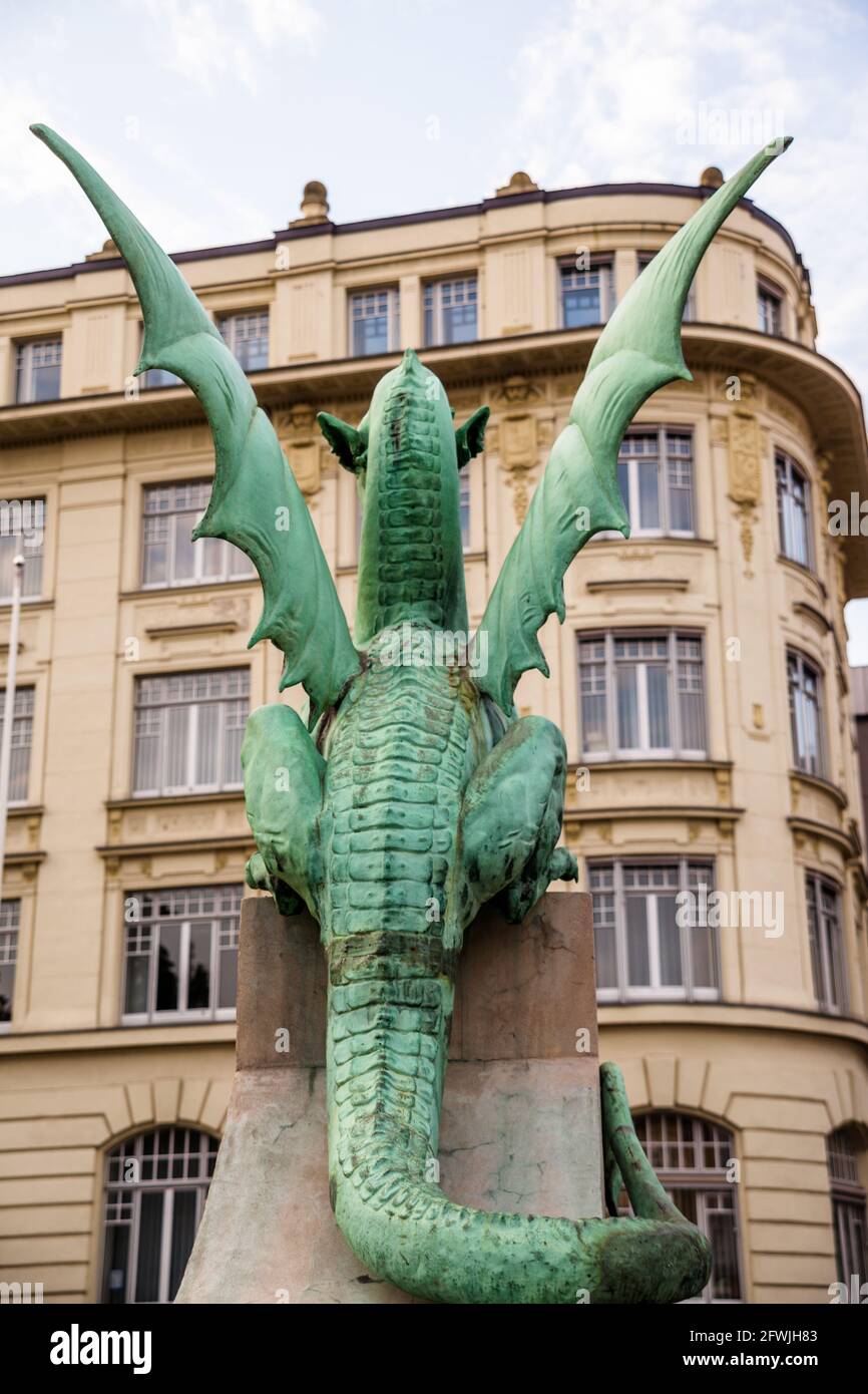 Rückansicht der Bronzestatue des sagenumwobenen Ljubljana-Drachen, der die Drachenbrücke bewacht, die den Fluss Ljubljanica überquert. Ljubljana, Slowenien Stockfoto