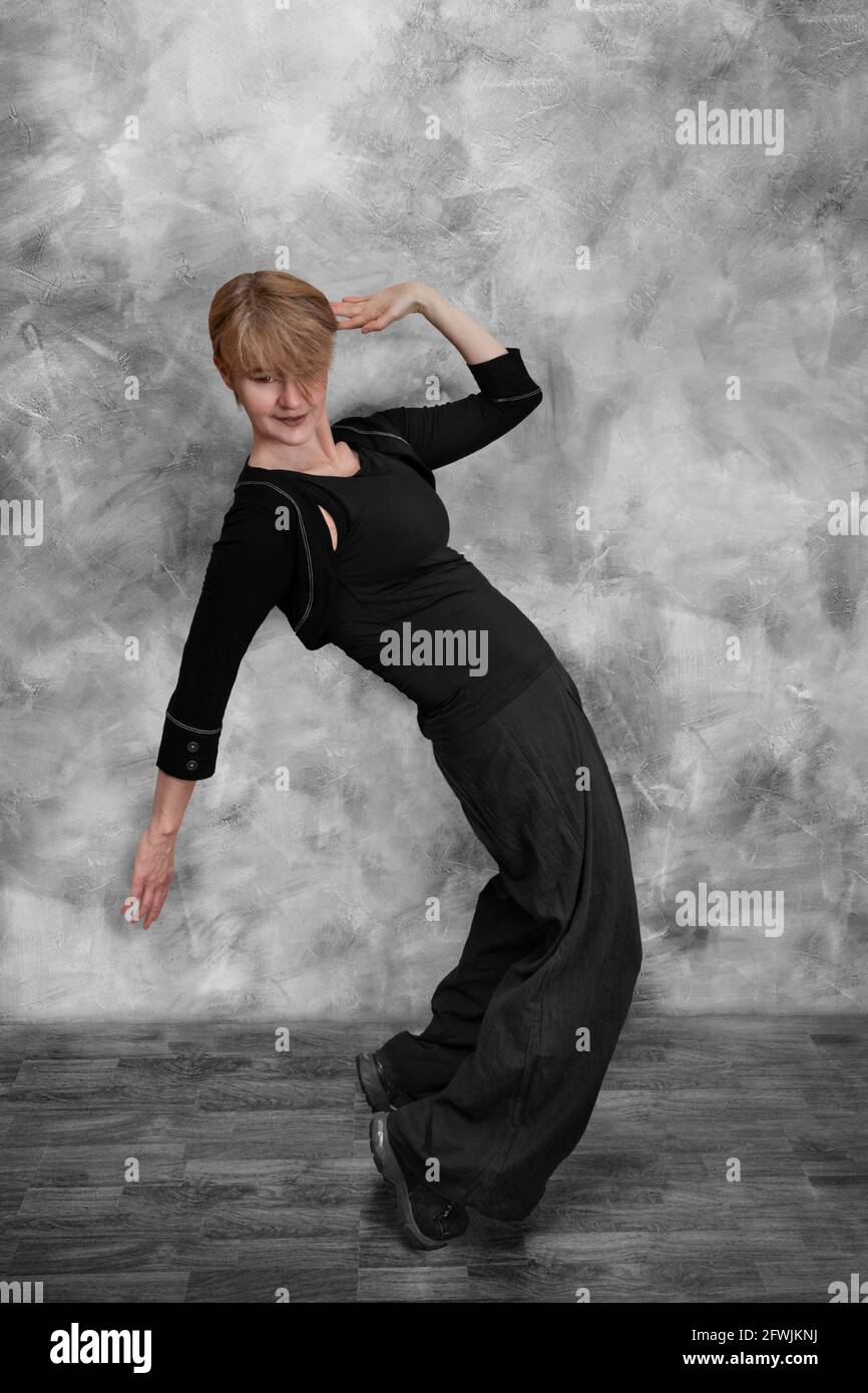Eine Frau in schwarzer Kleidung macht einen modernen Hip-Hop Tanzen Stockfoto