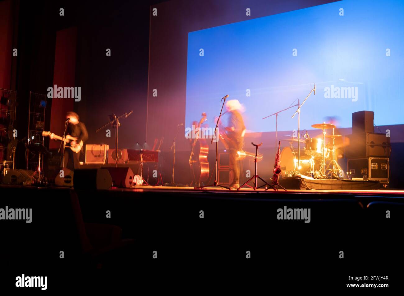 Musikalische Bühne mit verschwommenen Musikern, die vor dem Konzert in einem Auditorium Proben. Speicherplatz kopieren Stockfoto