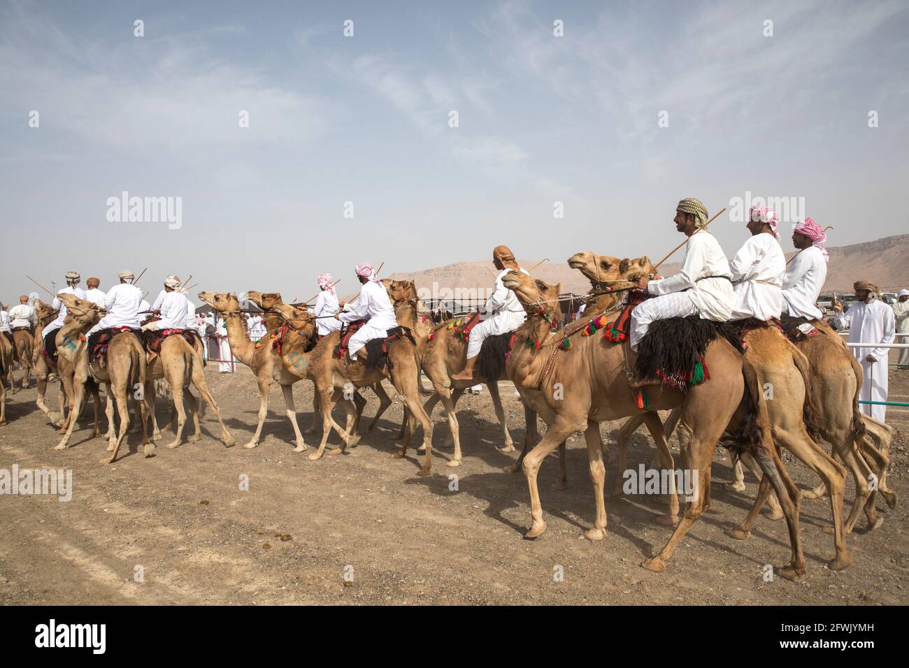 Khadal, Oman, 28. April 2018: omanische Männer in traditioneller Kleidung, auf Kamelen reiten Stockfoto
