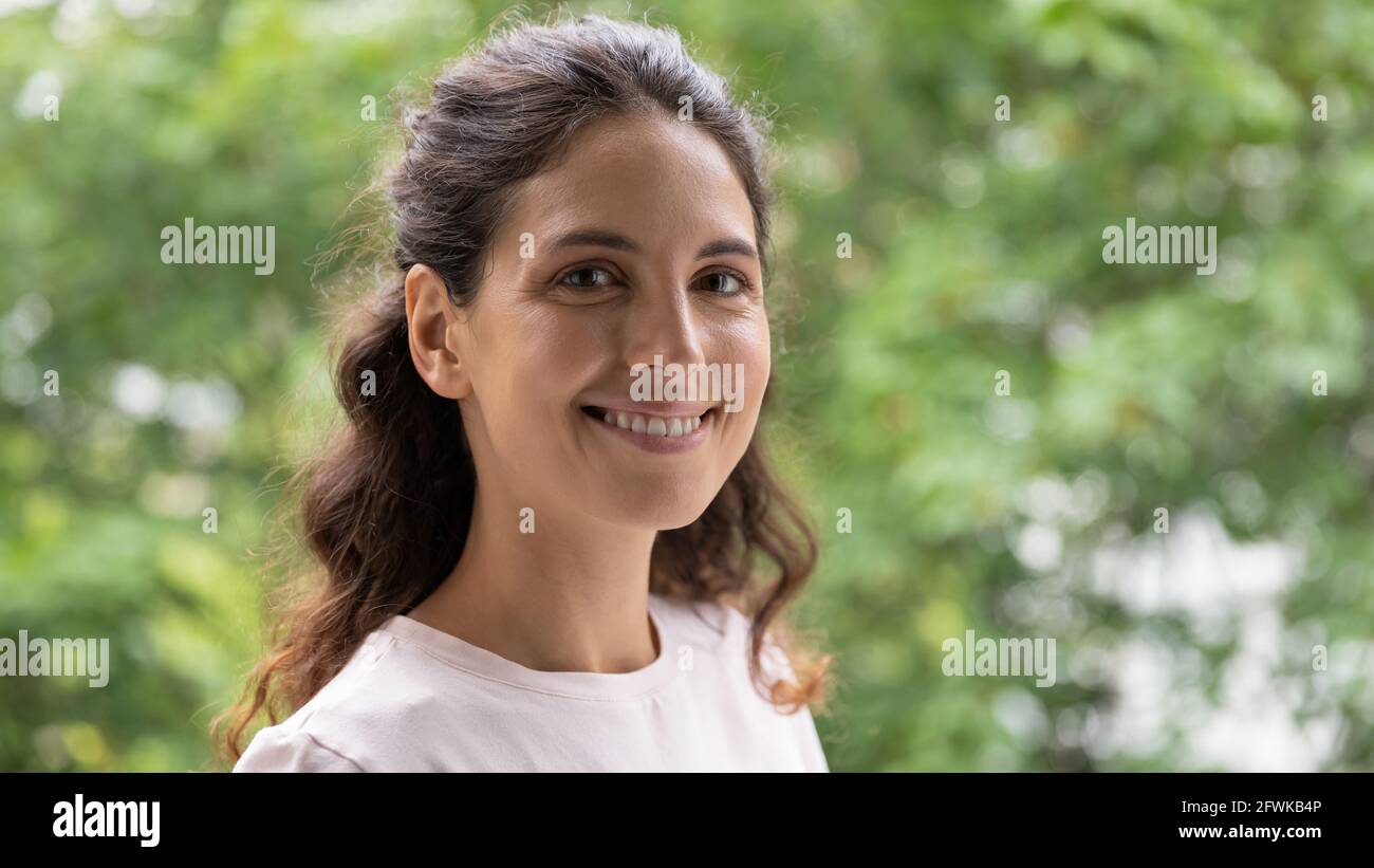 Emotional lächelnde junge lateinische Dame posiert vor der Natur. Stockfoto