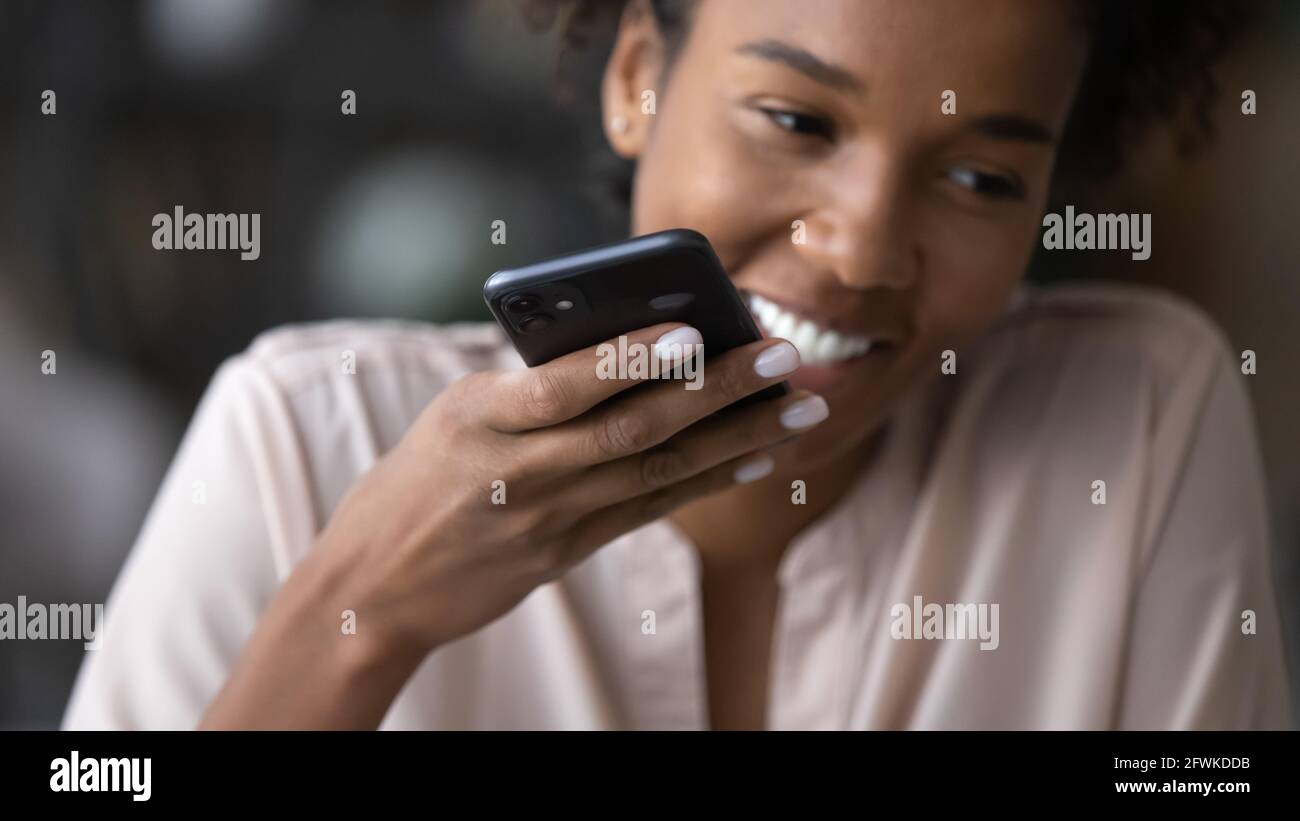 Glückliche junge afro brasilianische Frau Aufnahme Sprachnachricht. Stockfoto