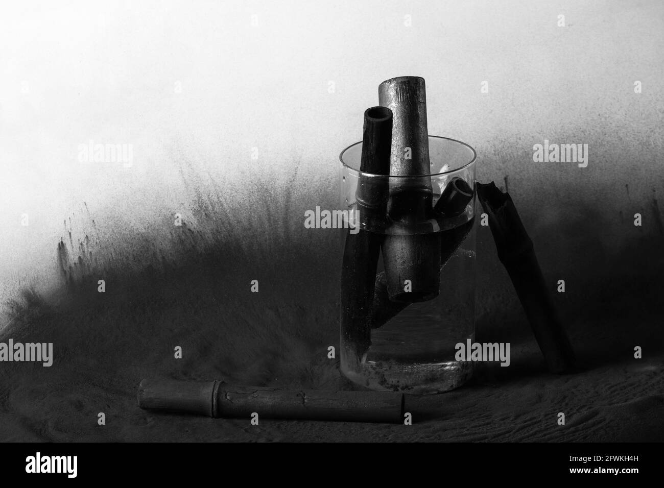 Bambus-Holzkohle-Sticks in Glas mit Wasser auf Kohlepulver schwarzen  Hintergrund. Leistungsstarker Wasserreiniger Stockfotografie - Alamy