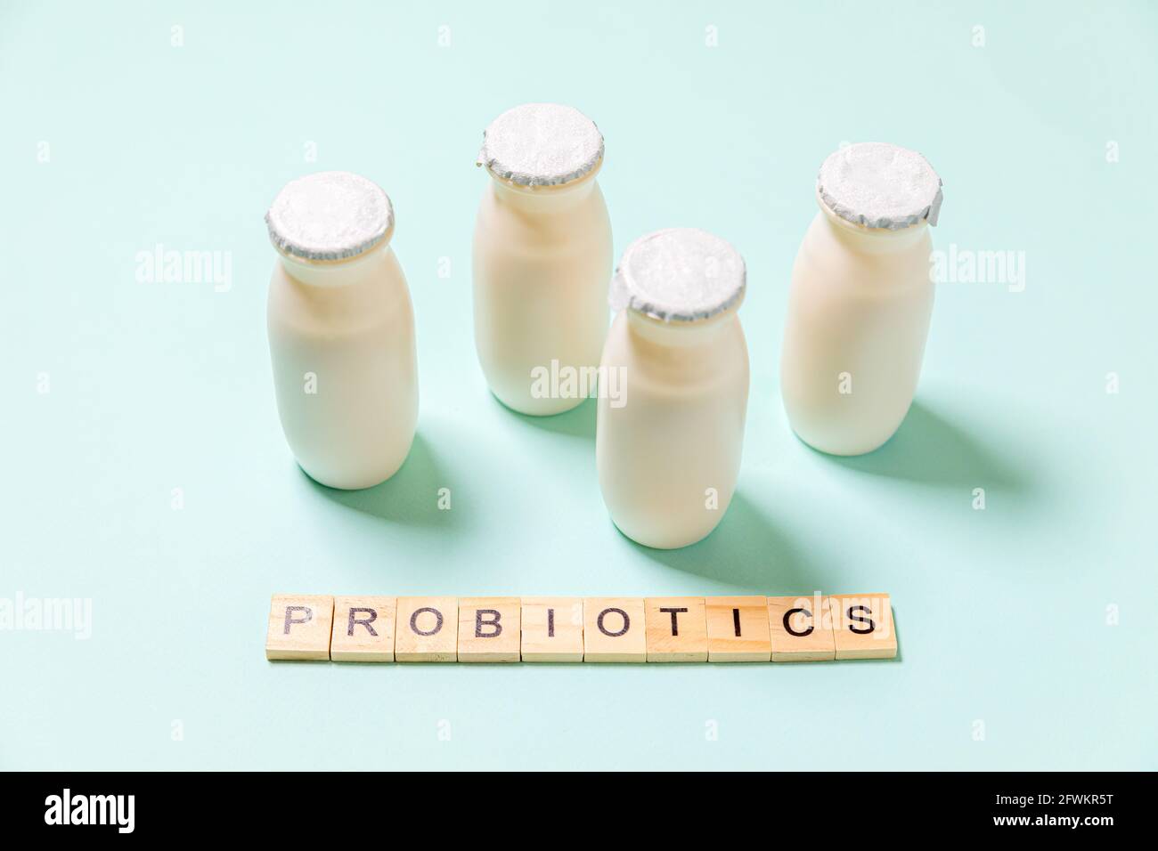 Kleine Flaschen mit Probiotika und Präbiotika Milchgetränk auf blauem Hintergrund. Herstellung mit biologisch aktiven Zusatzstoffen. Gärung und Ernährung Stockfoto