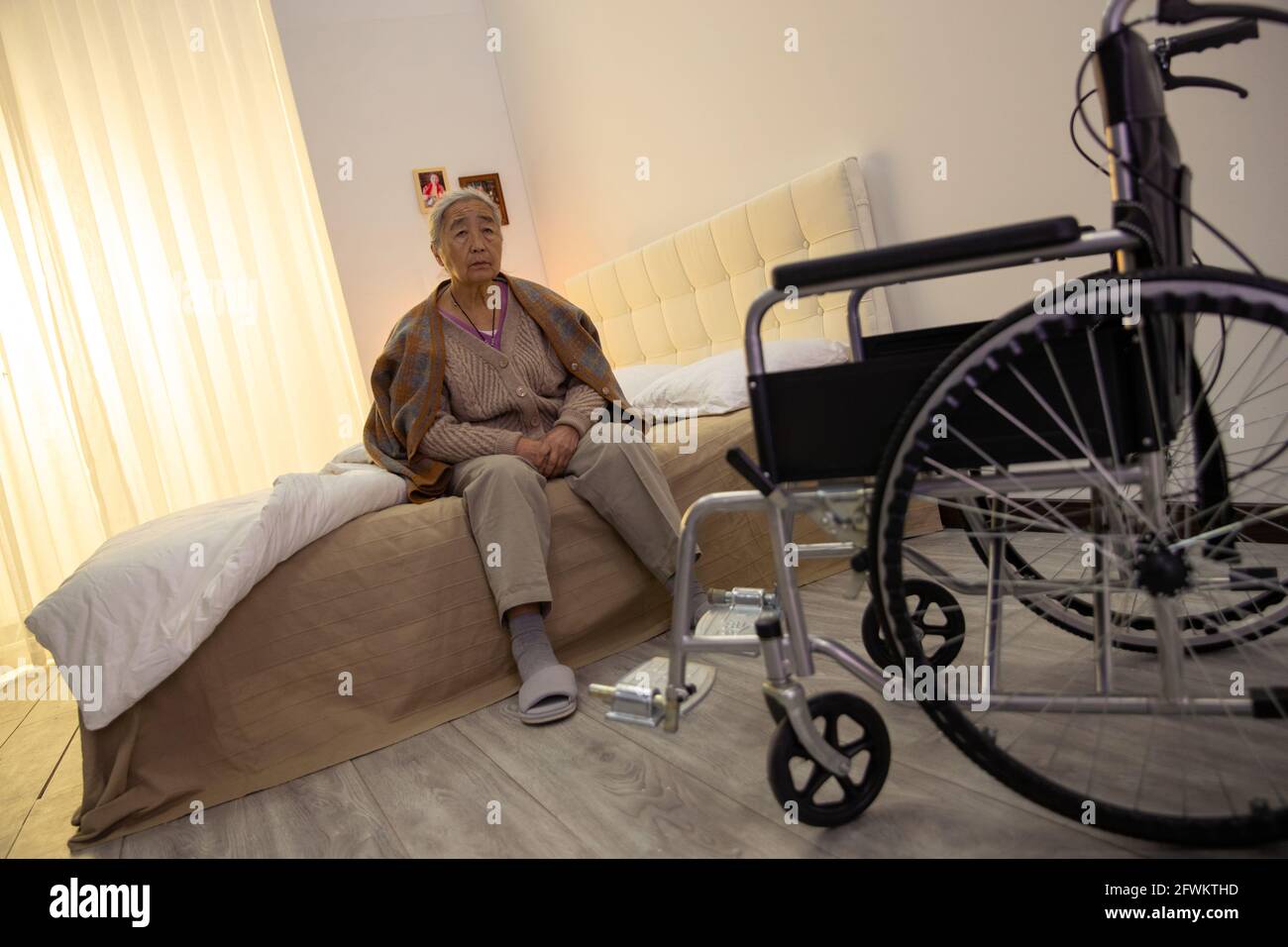 Der einsame alte Mann sitzt auf dem Bett Stockfoto