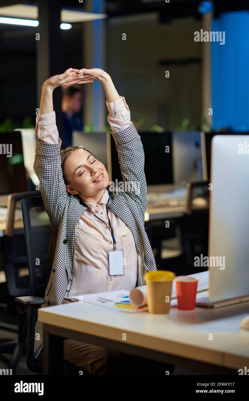Müde junge Frau arbeitet im Nachtbüro Stockfoto