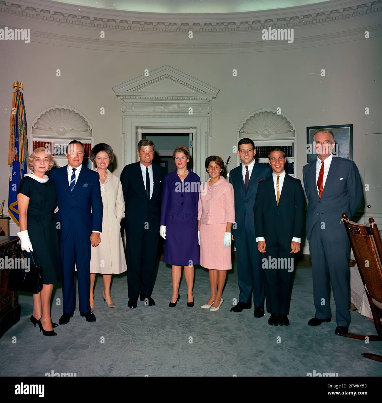 Präsident John F. Kennedy besucht den Schauspieler und Komiker Bob Hope und andere im Oval Office des Weißen Hauses, Washington, D.C.; Hope besuchte das Weiße Haus, um die Goldmedaille des Kongresses zu erhalten, die Präsident Kennedy als Anerkennung seiner Verdienste um das Land als Entertainer während des Zweiten Weltkriegs überreichte Von links nach rechts: Rita Millar, Ehefrau von Herrn Hope's Publizisten, Mack Millar; Herr Hope; Dolores Hope; der Präsident; Linda Hope; Nora Hope; Anthony Hope; William Kelly Hope; Senator Stuart Symington (Missouri). Stockfoto