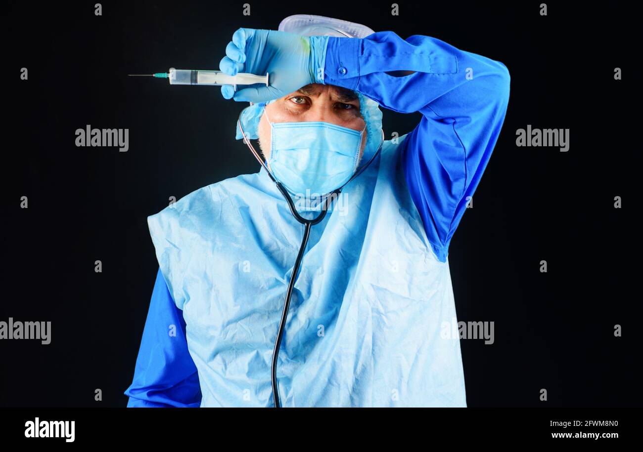 Impfung. Arzt im Schutzanzug, medizinische Maske, Schutzbrille mit Spritze. Krankenschwester, die sich für die Injektion vorbereitet. Stockfoto