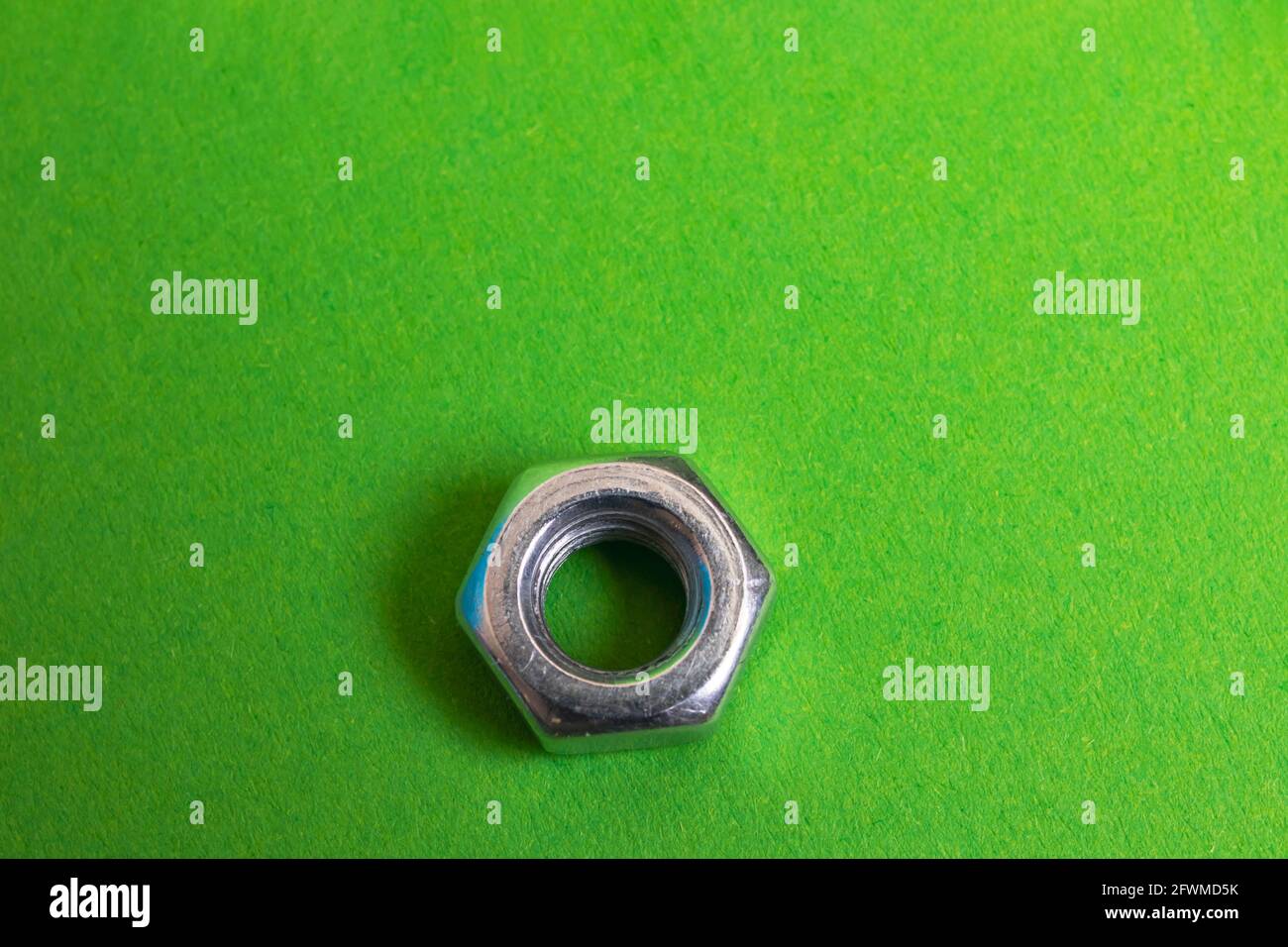 Metallmutter auf grünem Hintergrund Nahaufnahme, Platz kopieren Stockfoto