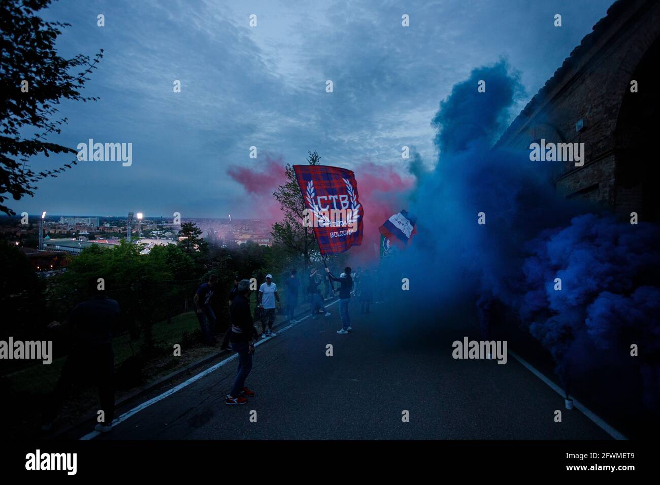 Bologna, Italien. Mai 2021. FC Bologna-Fans begrüßen das Team mit Fackeln, Schals und Flaggen vor dem letzten Spiel der Serie A in der Saison 2020-21 vom Hügel hinter dem Renato Dall'Ara Stadium. Kredit: Massimiliano Donati/Alamy Live Nachrichten Stockfoto