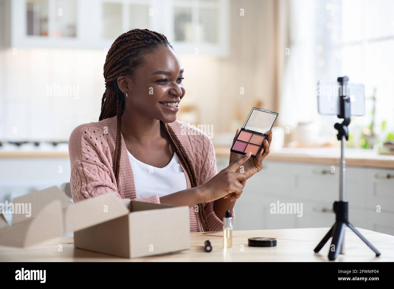 Beauty-Blogging. Happy Young African Influencer Lady Aufnahme Make-Up Bewertung In Der Küche Stockfoto