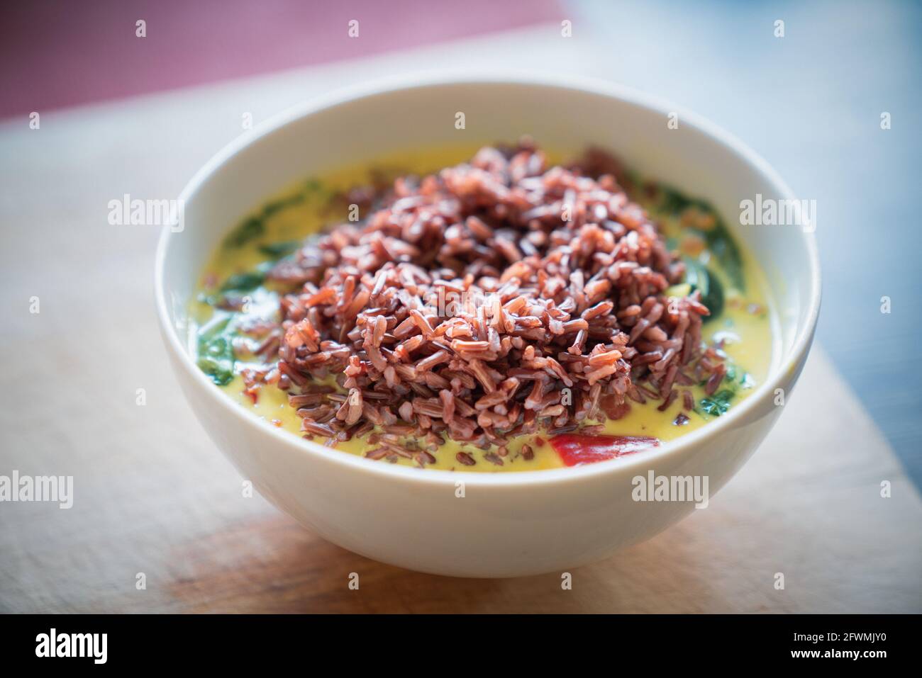 Schüssel mit Zucchini, Linsen und Spinateintopf mit rotem Reis Stockfoto