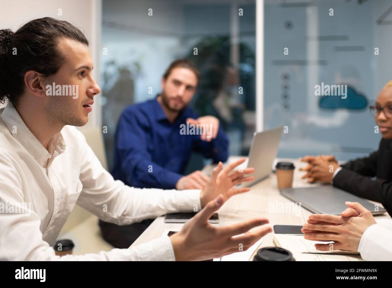 Männlicher Manager im Gespräch mit multiethnischen Kollegen Stockfoto