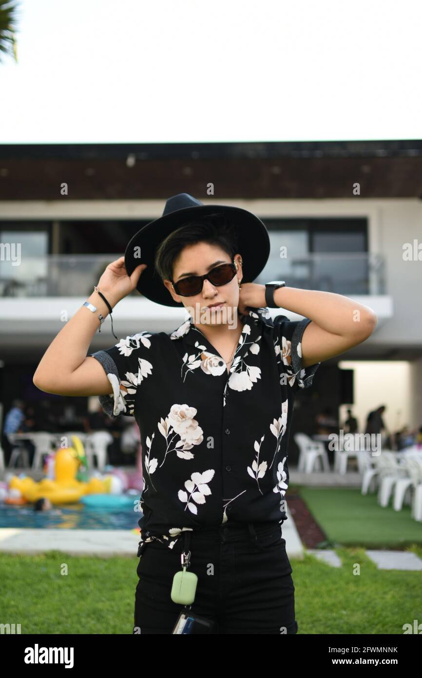 Einflussreiches Mädchen mit Brille und schwarzem Outfit posiert entspannen Stockfoto