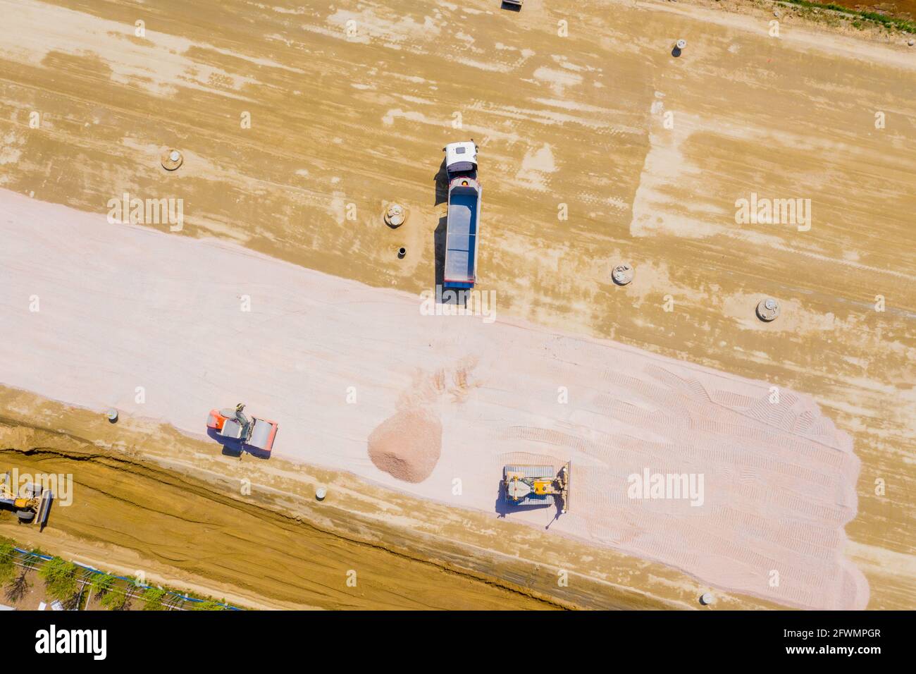 Luftaufnahme von Bulldozer gießt Sand in den LKW. Auf die Nachteile Stockfoto