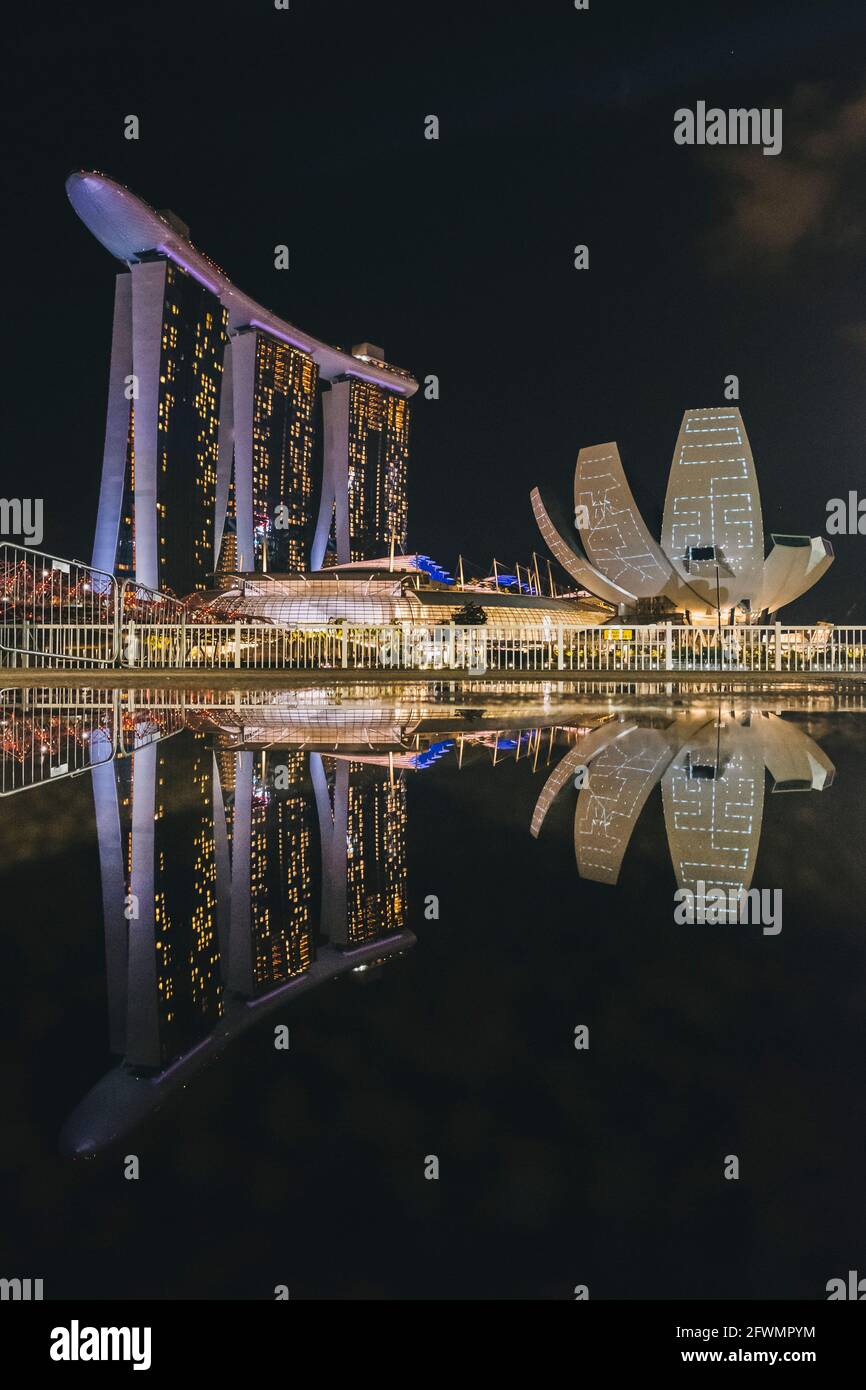 Marina Bay Sands und ArtScience Museum spiegeln sich in einem Regen wider Pfütze bei Nacht in Singapur Stockfoto