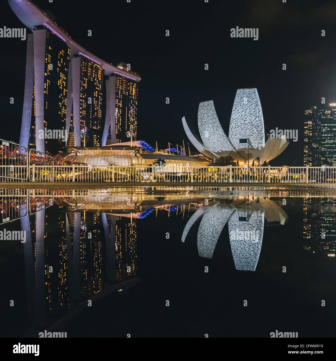 Marina Bay Sands und ArtScience Museum spiegeln sich in einem Regen wider Pfütze bei Nacht in Singapur Stockfoto