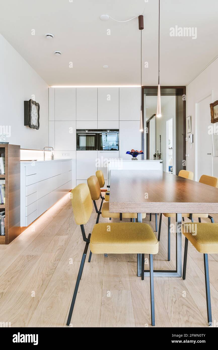 Essbereich mit Tisch und Stühlen und Hängelampen Modernes, helles, minimalistisches Apartment mit offener Küche Stockfoto
