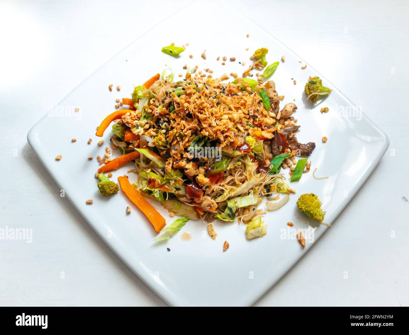 Pad Thai Vegan, Reisnudel mit sautiertem Gemüse, Broccoli, Karotte, weiße und grüne Zwiebel, Austernpilze, gehackte Erdnüsse Stockfoto