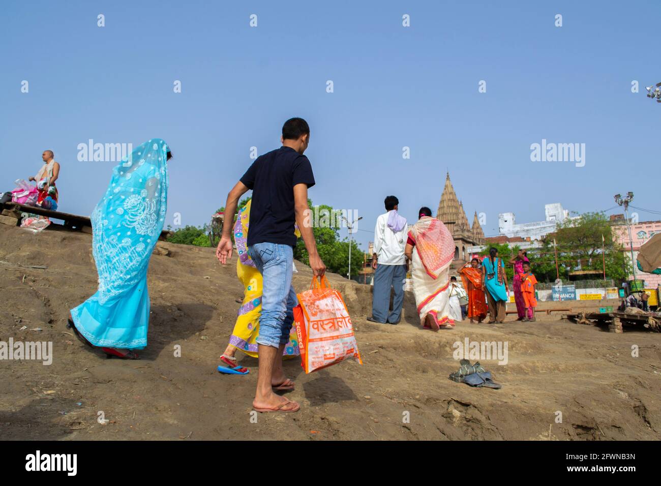 Varanasi, Indien. Menschen, die über trockene Ufer des Ganges wandern Stockfoto