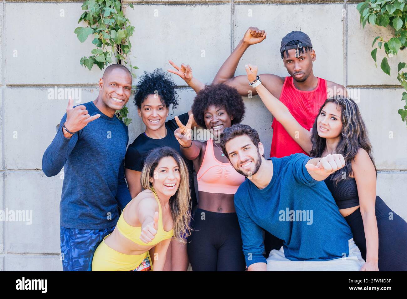 Porträt einer Gruppe von Läufern, die mit erhobenen Fäusten lächelnd auf die Kamera lächeln. Stockfoto