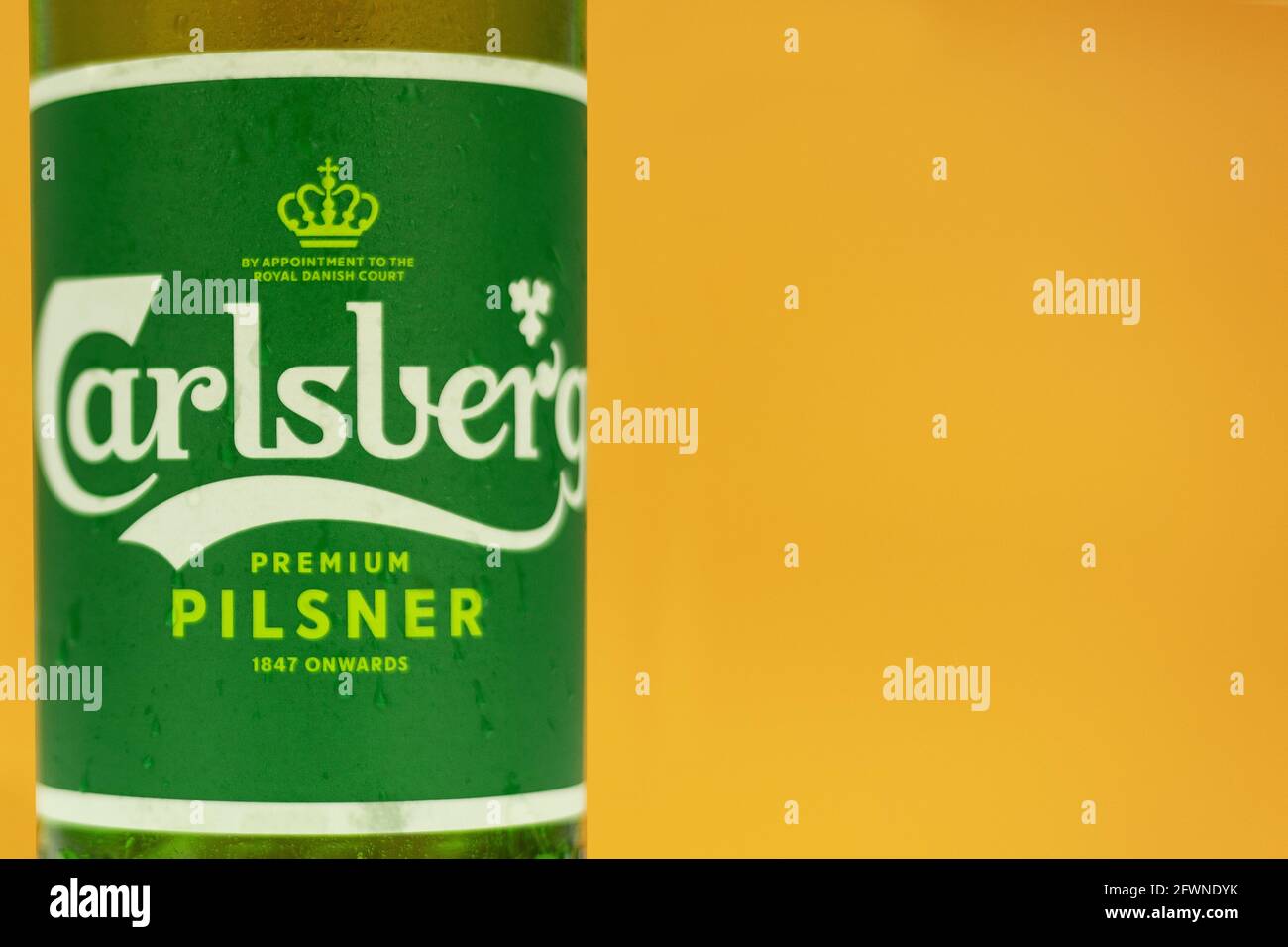 Warschau, Polen - 20. Mai 2021: Frisches carlsberg-Bier in einer Glasflasche aus der Nähe. Hintergrund mit Platz für Text. Auf gelbem Hintergrund isolieren Stockfoto