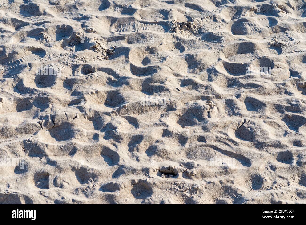 Klare Textur von beigefarbenem Wellensand.Nahaufnahme des Sandtextur-Hintergrunds am Strand. Stockfoto