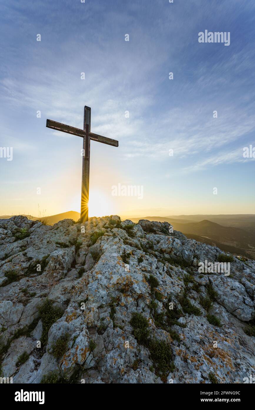 Christliches Symbol, hölzernes katholisches Kreuz auf dem Gipfel eines Berges bei Sonnenaufgang. Stockfoto