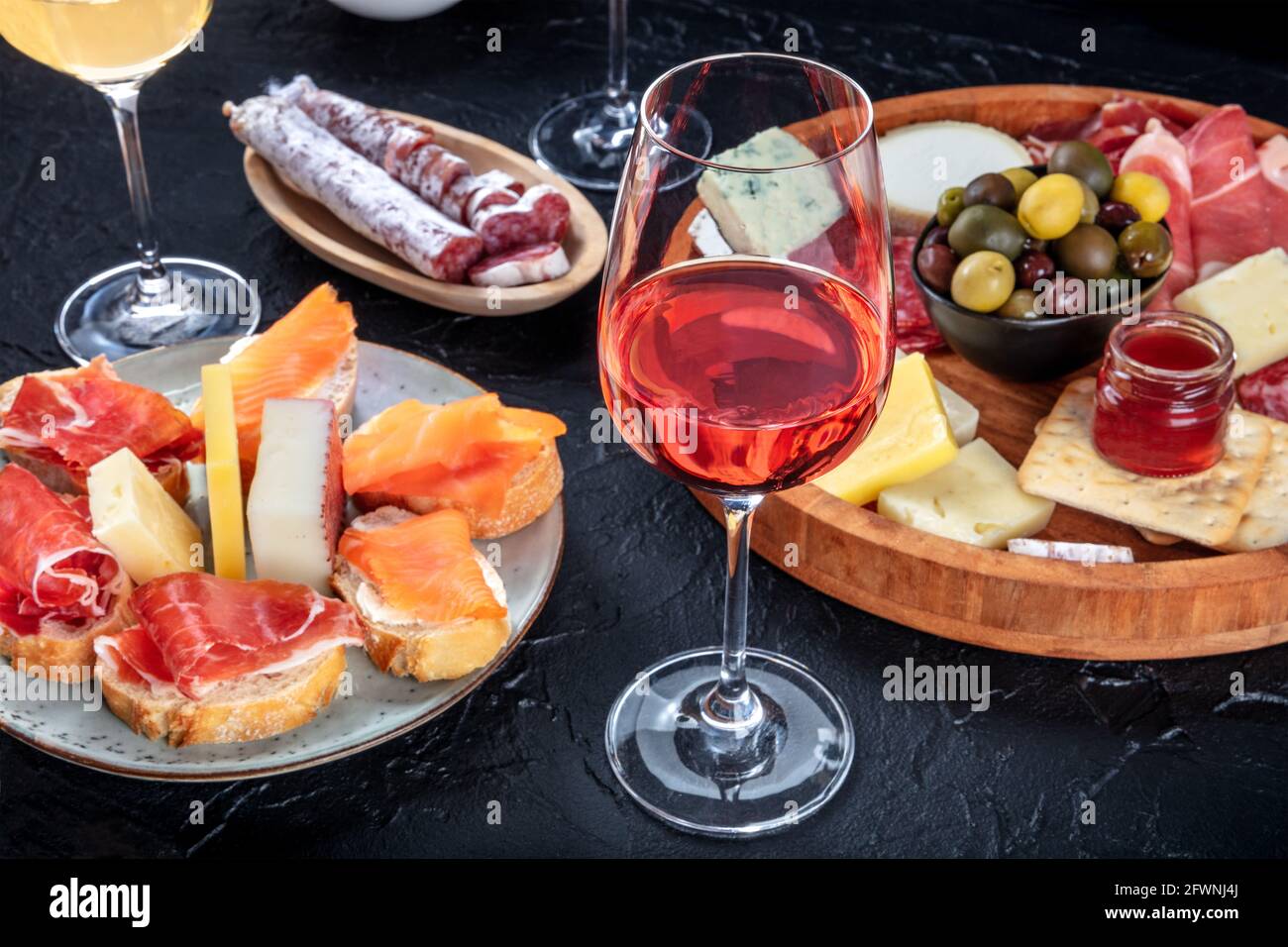 Roséwein und italienische Antipasti oder spanische Tapas in einer Bar. Blauschimmelkäse, Schinken aus Parmaschinken, Jamon, Oliven und Samon-Sandwiches Stockfoto