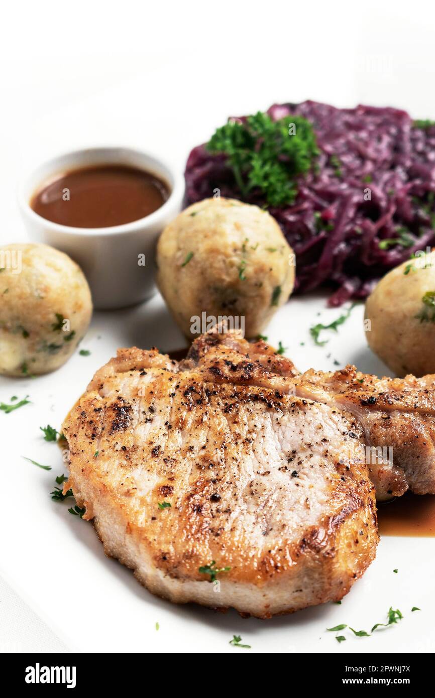 gegrilltes Schweinekotelett im deutschen Stil mit Brotknödeln und Rot Traditionelle Kohl-Mahlzeit auf weißem Hintergrund Stockfoto