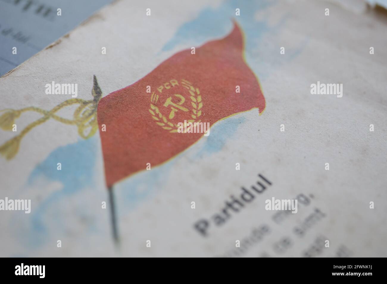 Marghia, Rumänien - 5. Mai 2021: Geringe Schärfentiefe (selektiver Fokus) Details mit einer rumänischen kommunistischen Parteiflagge und nationalistischem Gedicht in einem alten Stockfoto