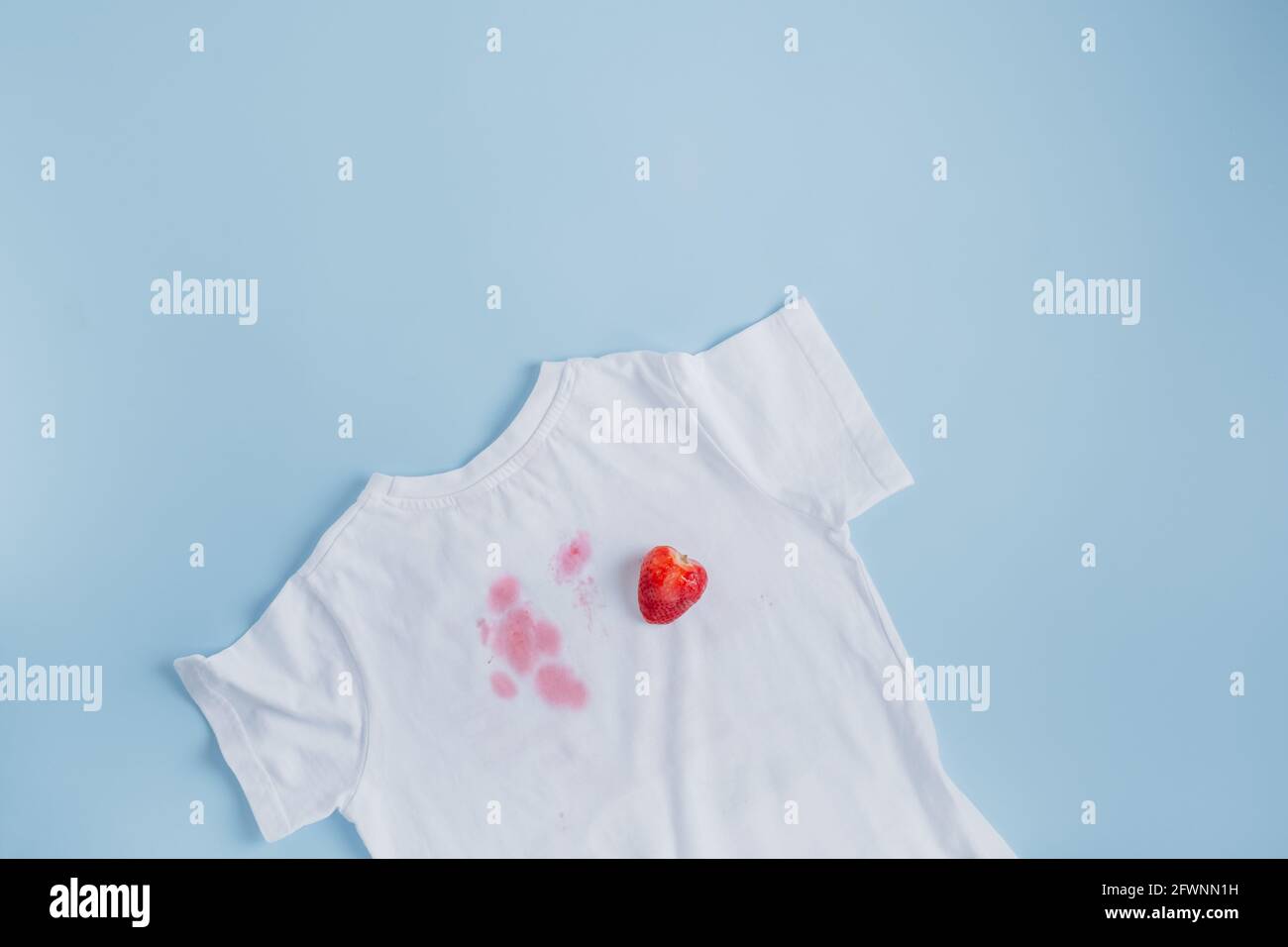 Schmutzige Erdbeerfleck auf weißen Kleidern. Alltag schmutzige Fleck für Wasch- und Reinigungskonzept Stockfoto
