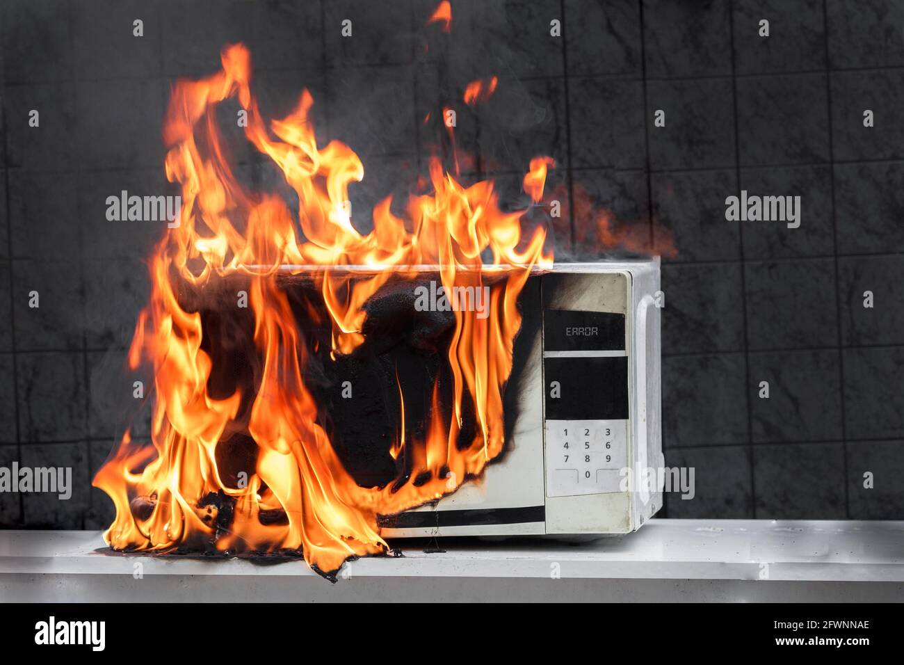 Mikrowellenofen brennt, Hausbrand aufgrund von unsachgemäßem Betrieb, spontane Verbrennung fehlerhafter Geräte Stockfoto