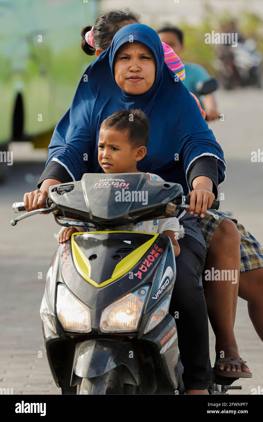 Eine Frau in Hijab fährt mit 2 Kindern und einem Erwachsenen in diesem Ferienort im äußersten Süden: Tanjung Bira, Süd-Sulawesi, Indonesien Stockfoto