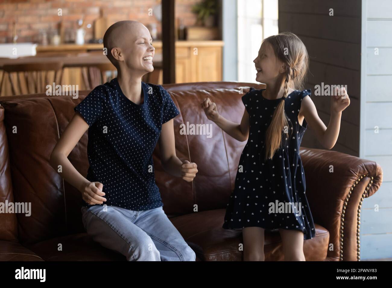 Aufgeregt haarlose Mutter mit Krebs und glückliches kleines Mädchen Stockfoto