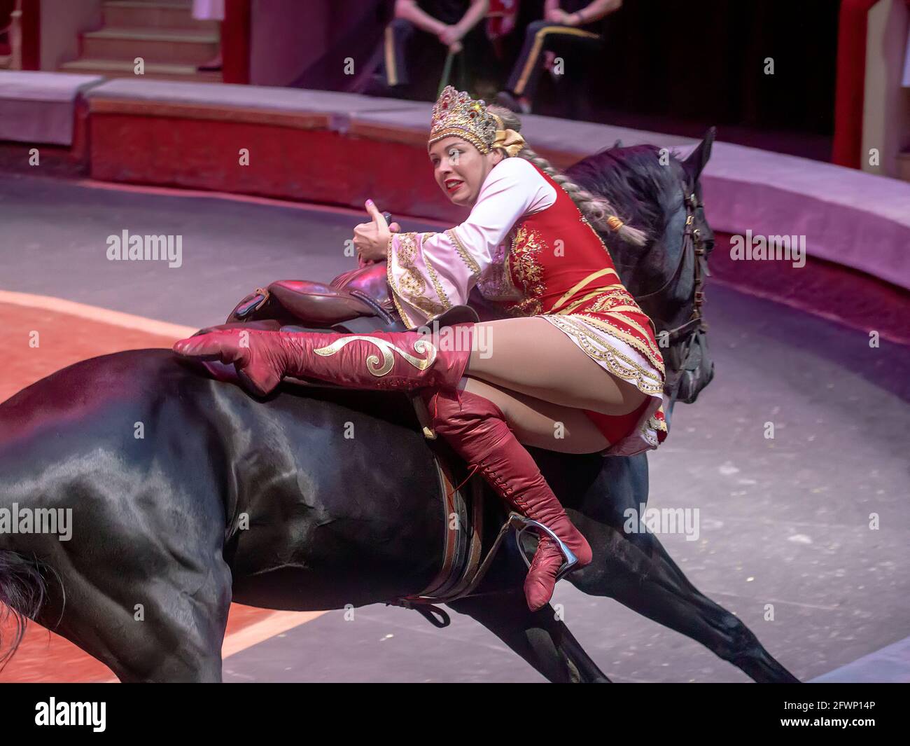 Sankt Petersburg, Russland 08-18-2019. Künstler auf dem Pferderücken bei Dressur und Akrobatik in einer Zirkusvorstellung. Stockfoto