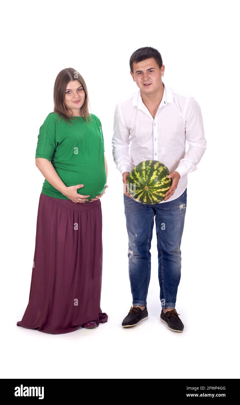 Ein Mann und eine Schwangere halten eine große Wassermelone in den Händen. Isoliert auf weißem Hintergrund Stockfoto