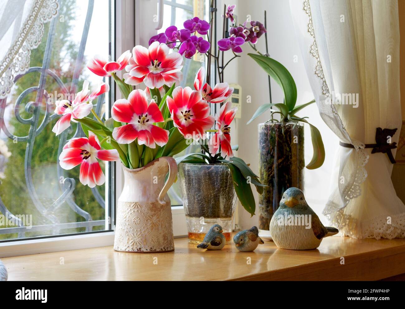 Schöner Frühlingsstrauß aus Tulpen in einer Vase auf einer Fensterbank in einem Privathaus Stockfoto