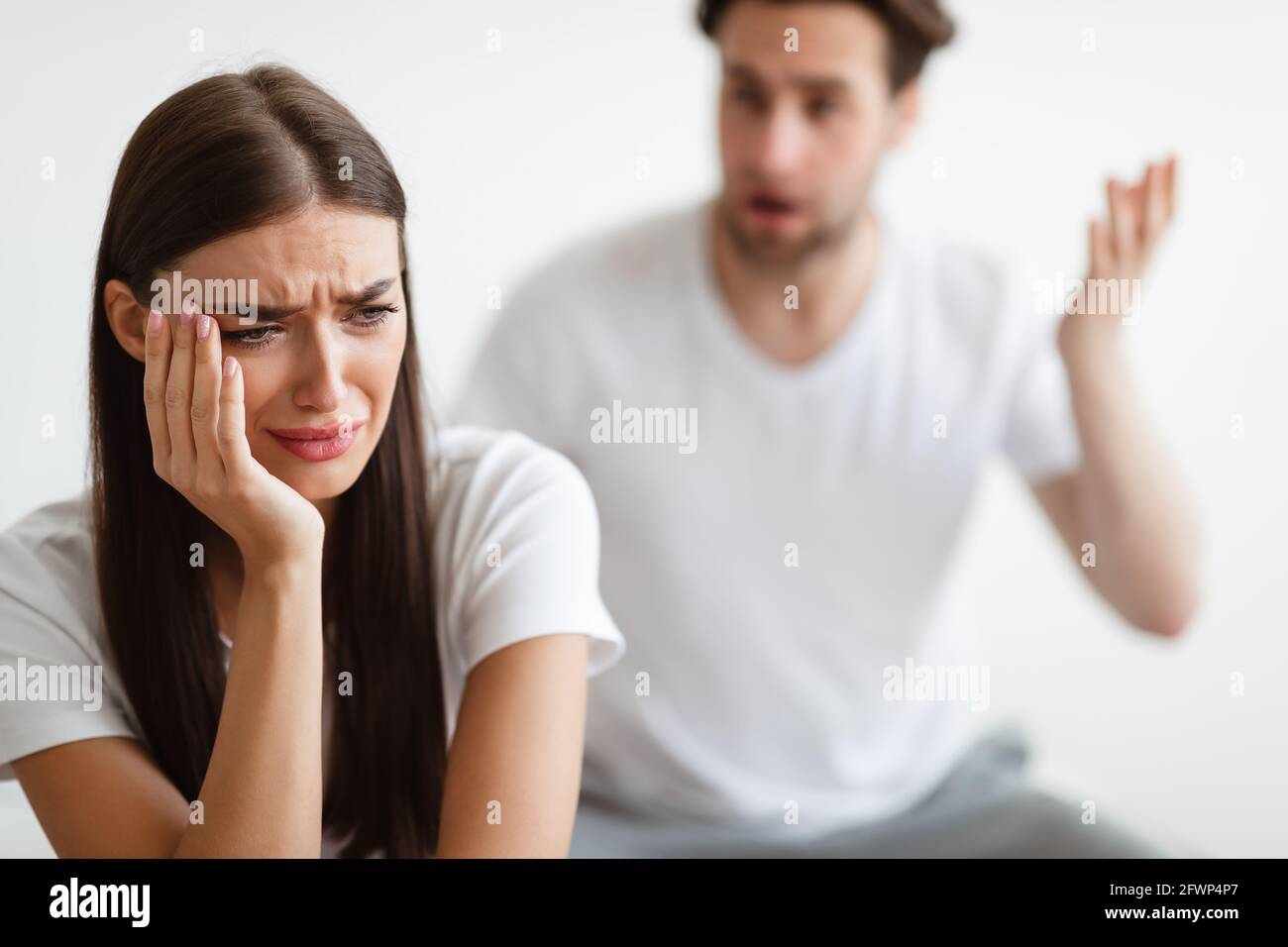 Frau weinte, während ihr aggressiver Ehemann im Schlafzimmer anschrie Stockfoto