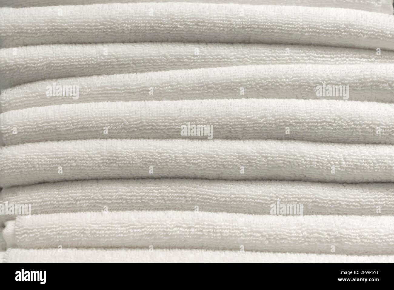 Der Hintergrund ist ein Stapel weißer Handtücher. Heimtextilien, neue Handtücher Textur. Stockfoto