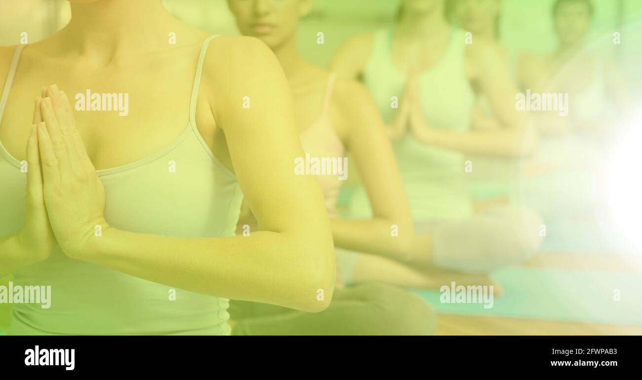 Zusammensetzung der Gruppe von Frauen, die Yoga mit grünem Farbton praktizieren Stockfoto