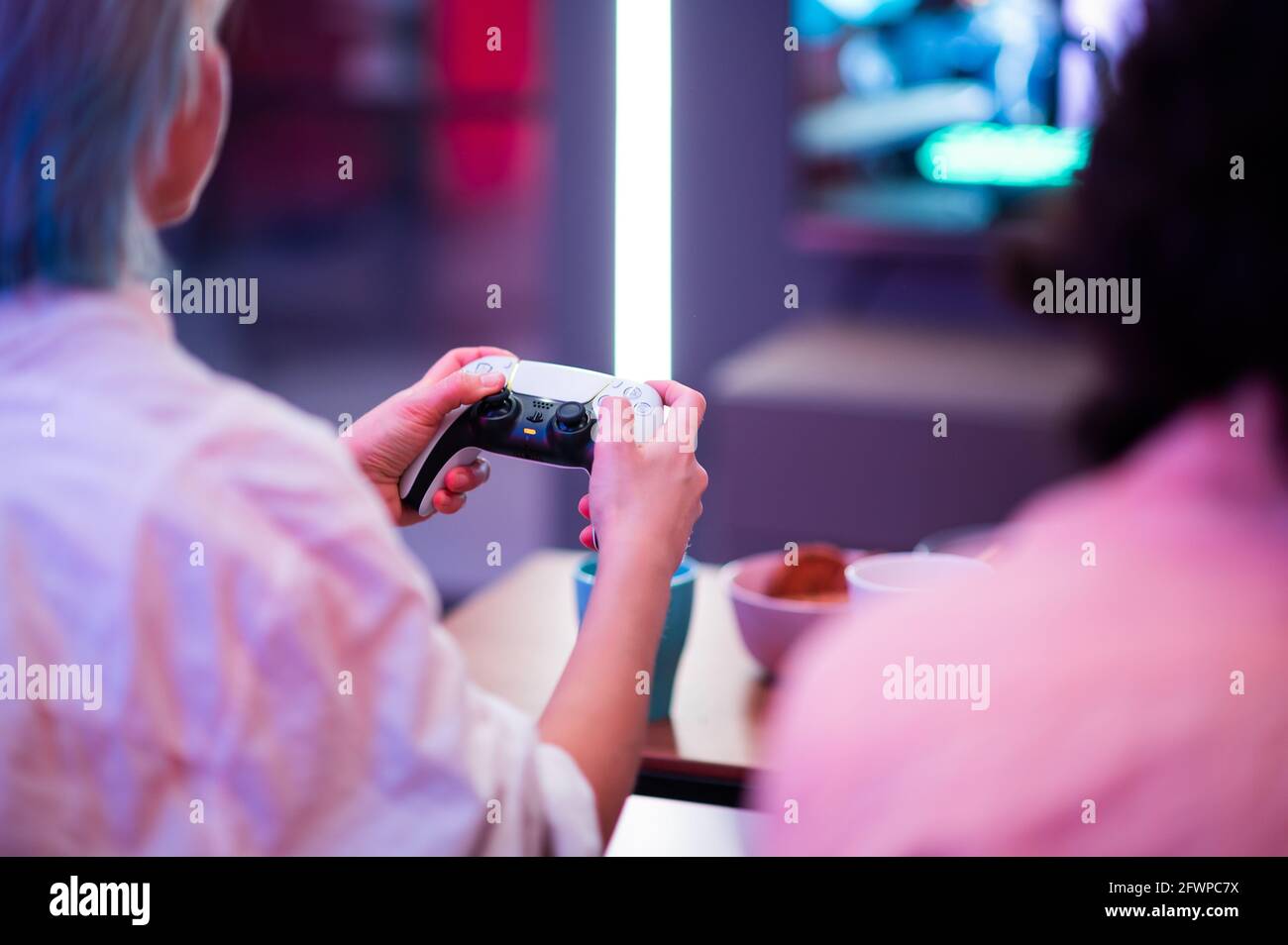 Nahaufnahme der Hände einer Spielerin, die mit dem DualSense PS5-Joystick Videospiele auf der PlayStation 5-Spielkonsole spielt. Moskau - November 28 2020 Stockfoto
