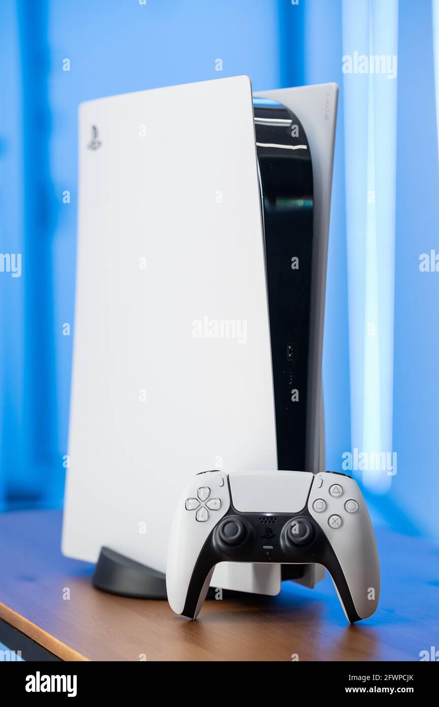 Die neue Sony Spielekonsole PlayStation 5 und der DualSense Controller in einem pinken Neonlicht. Moskau - November 28 2020 Stockfoto