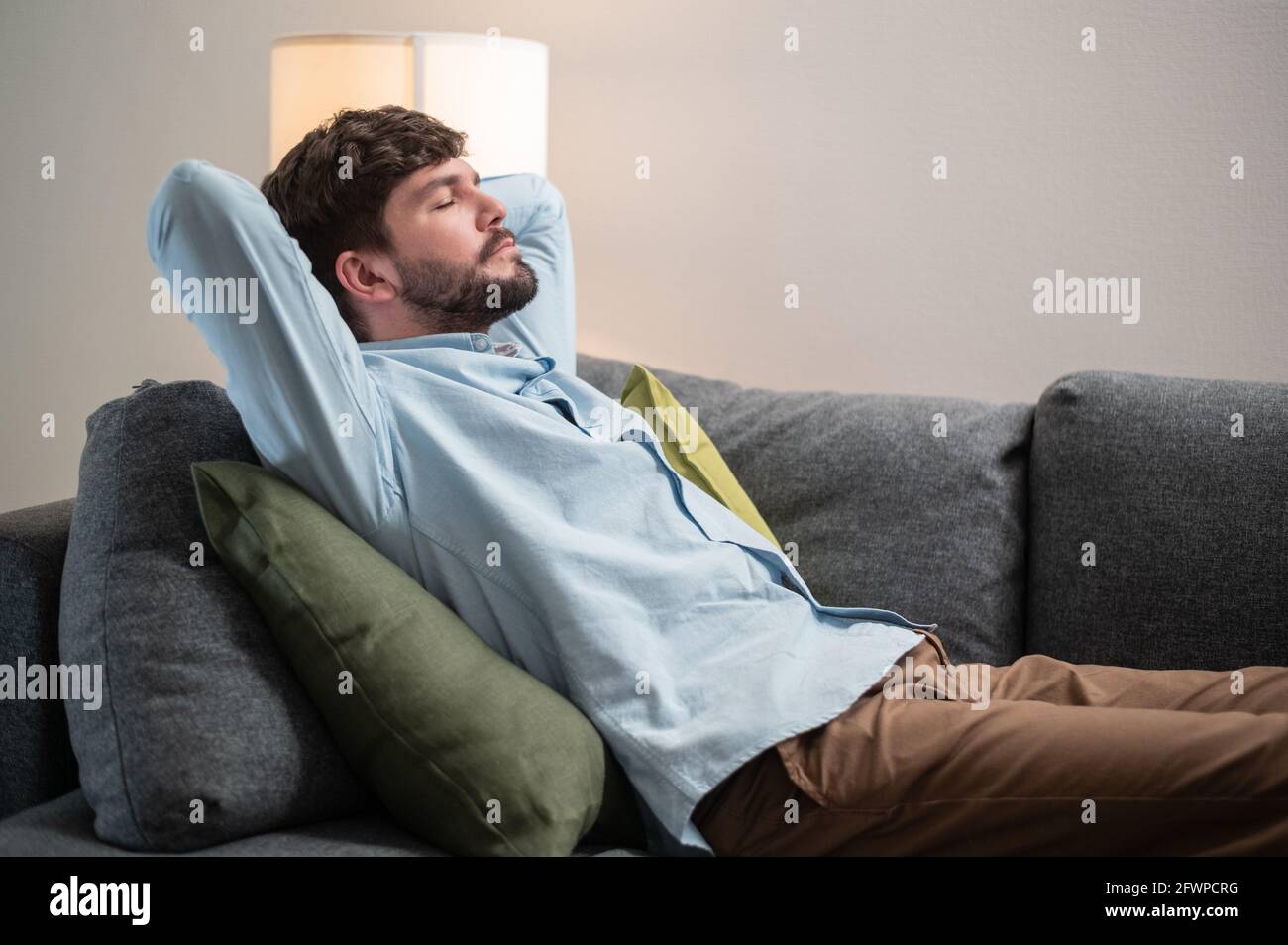 Während der Quarantänezeit des Coronavirus schläft ein Büromitarbeiter bei einem Remote-Job zu Hause auf dem Sofa. Stockfoto