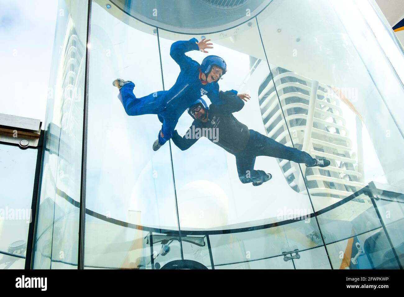 Ein kleiner Junge, der einen Fallschirmsprung in einem vertikalen Windkanal an Bord des Royal Caribbean-Schiffes Anthem of the Seas simuliert. Stockfoto