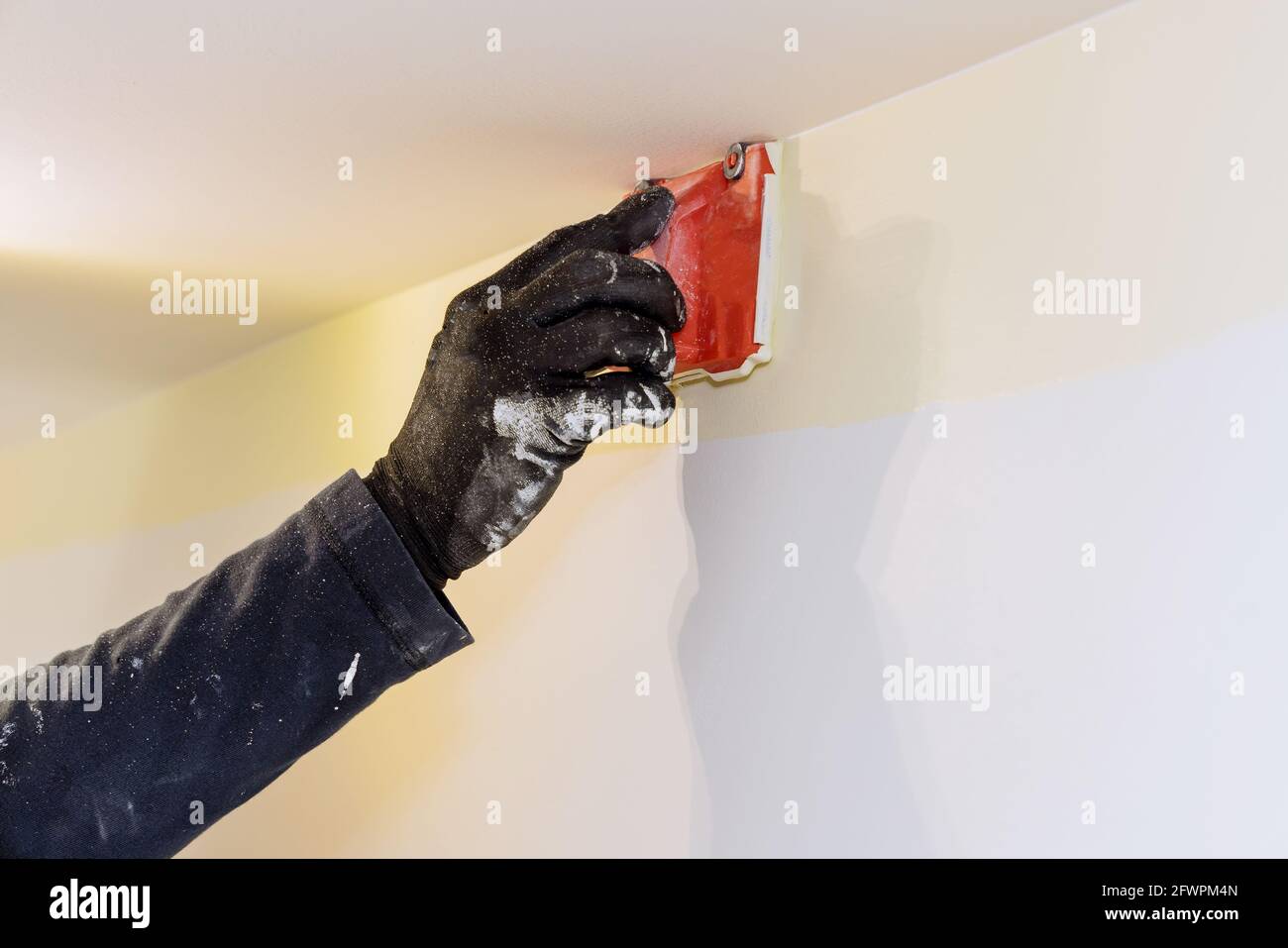 Hausrenovierung für den arbeitenden Auftragnehmer Benutzer in Ecklackiermaschine Pinsel Maler Hände mit Malerei die Wand Stockfoto