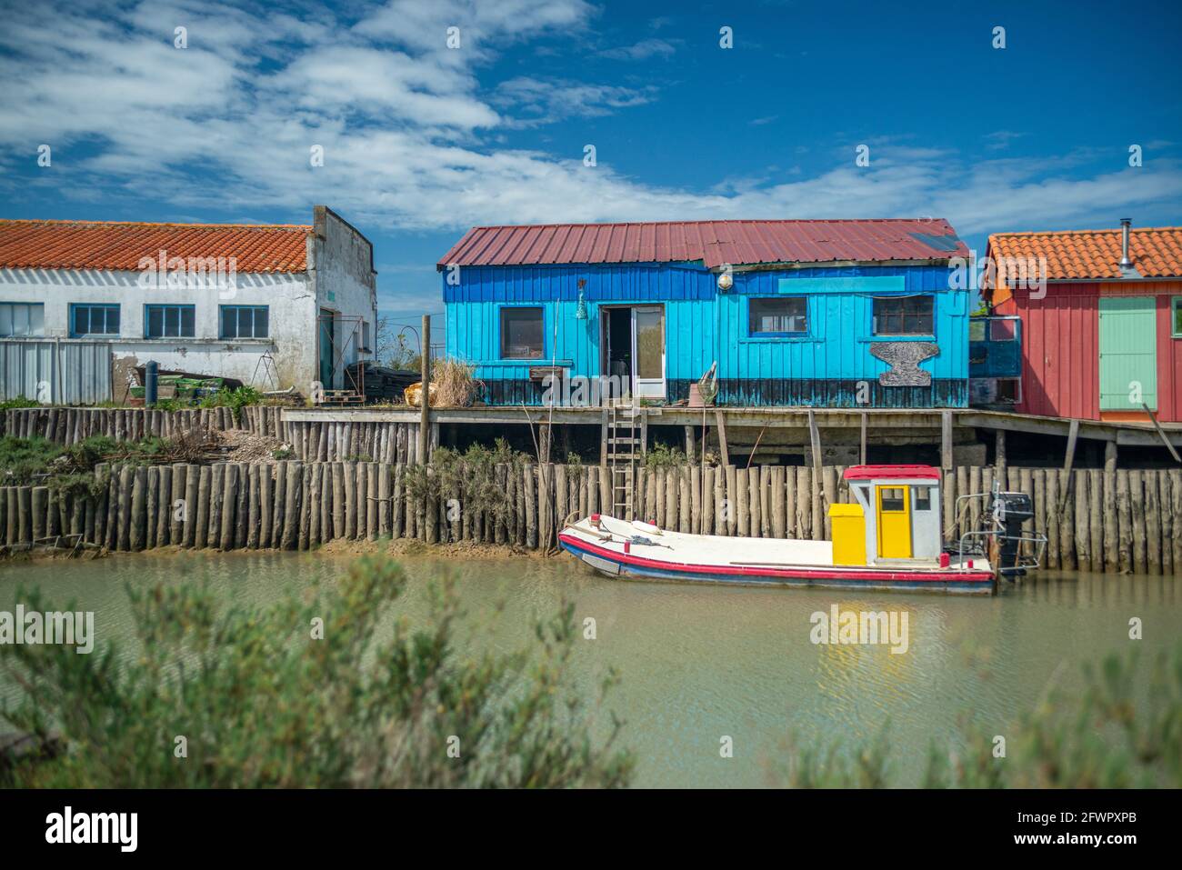 Farbenfrohe Austernhütten und Austernboot im Hafen, Oleron Island, Charente Maritime, Frankreich an der Westatlantikküste Stockfoto